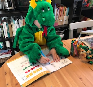 The author's child doing math dressed as a dragon.